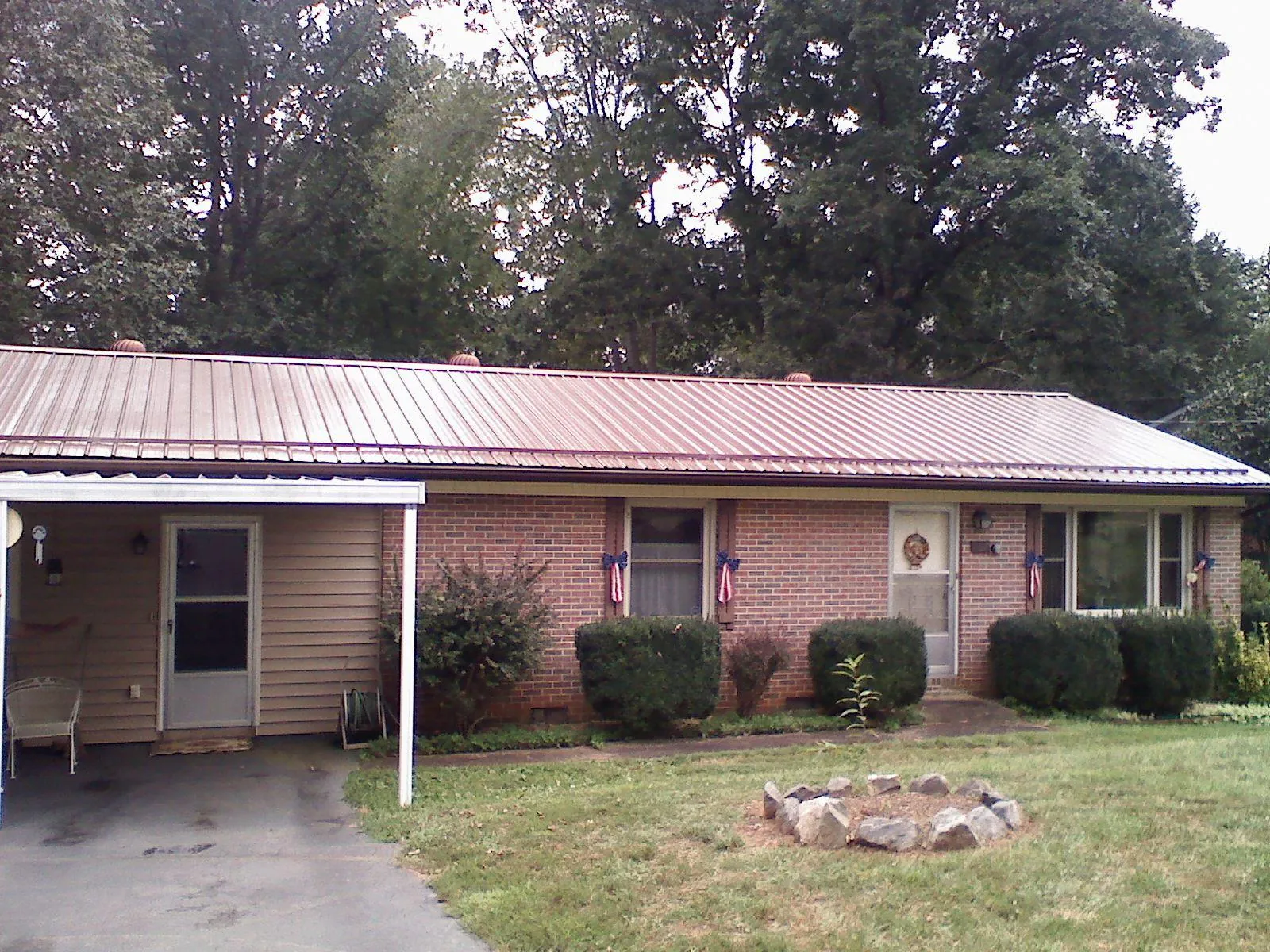 Bronze metal roof and carport on a brick ranch home — Roof Repair work by our crew in Burton