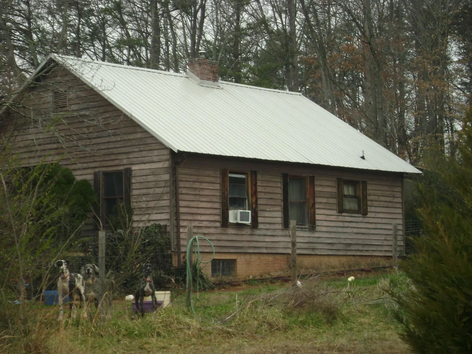 White metal roof on an old wood sided farmhouse, from a Metal Roof Installation job in Burton